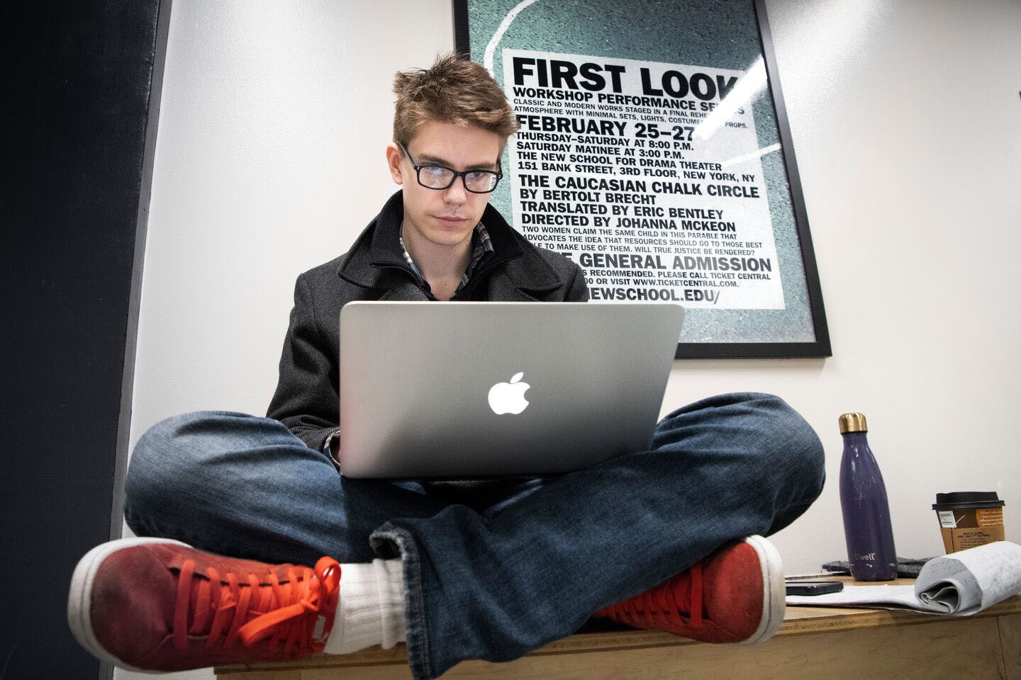 一个男学生在一台台式电脑上打字.