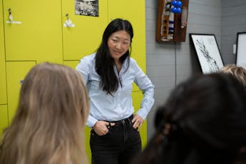 Master of the Arts in Fashion Studies program professor Christina Moon talks with students in the university’s Kellen Archives, which houses work by Parsons alumni.