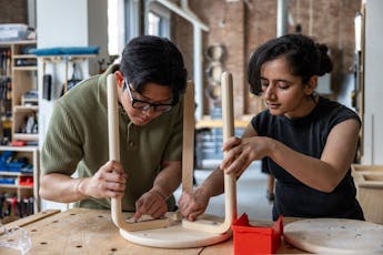 First year students making a stool in the wood shop.
