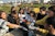 Students in a first-year course are shown working together on a Parisian green roof, taking scoops of soil for a garden seen behind them.