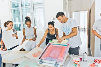 A group of students engage with a printmaking process during orientation.
