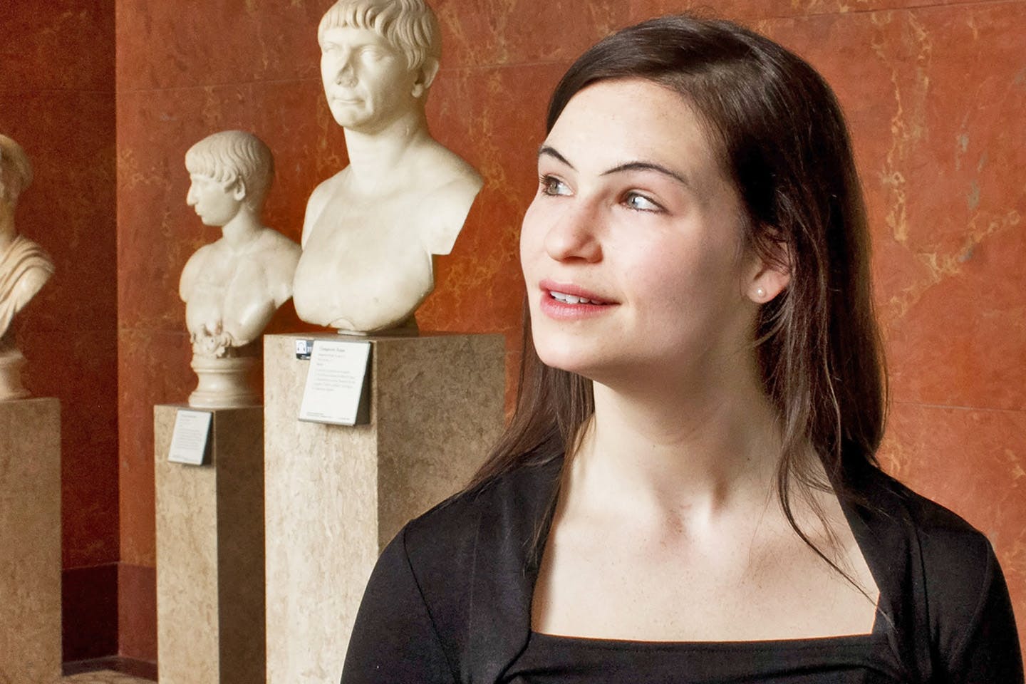 Headshot of faculty member Stephanie Nadalo with museum sculptures in the background.