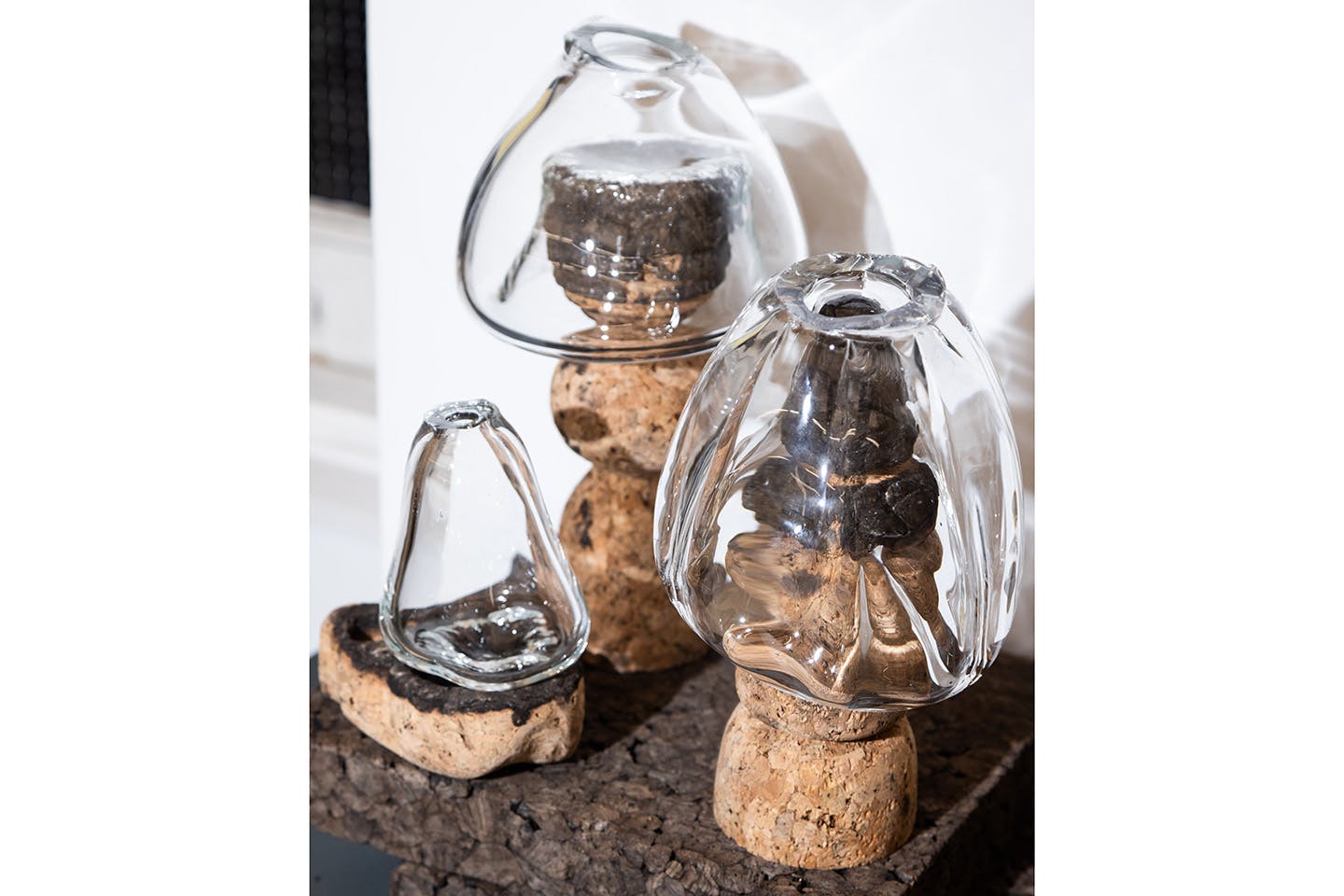Photograph of a cordless LED lamp designed by Katarzyna Kubrak, featuring a textured glass shade blown into a cork mold, which also forms the lamp’s sculptural cork base.