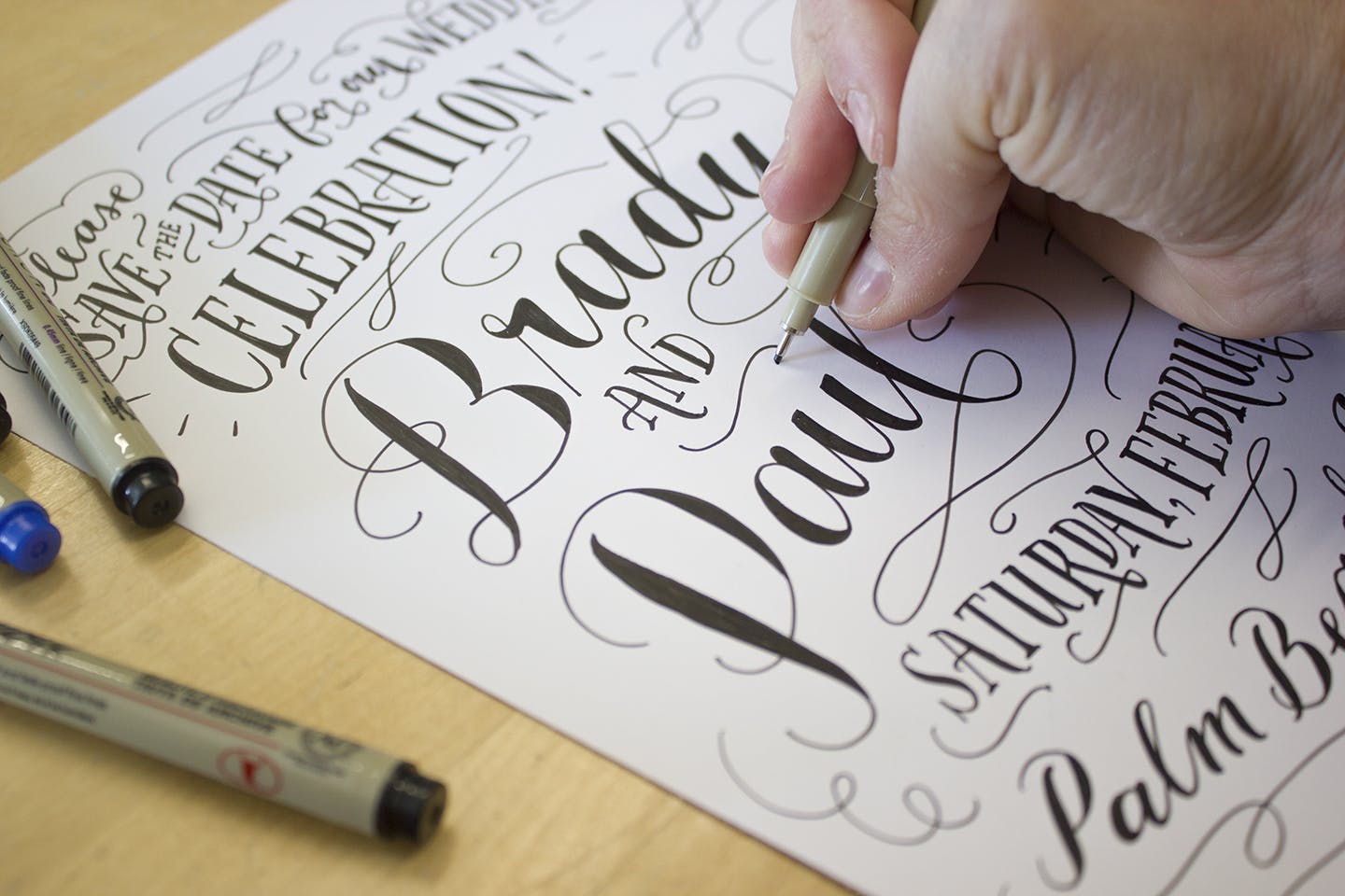 Torsone hand-lettering a custom wedding invitation.