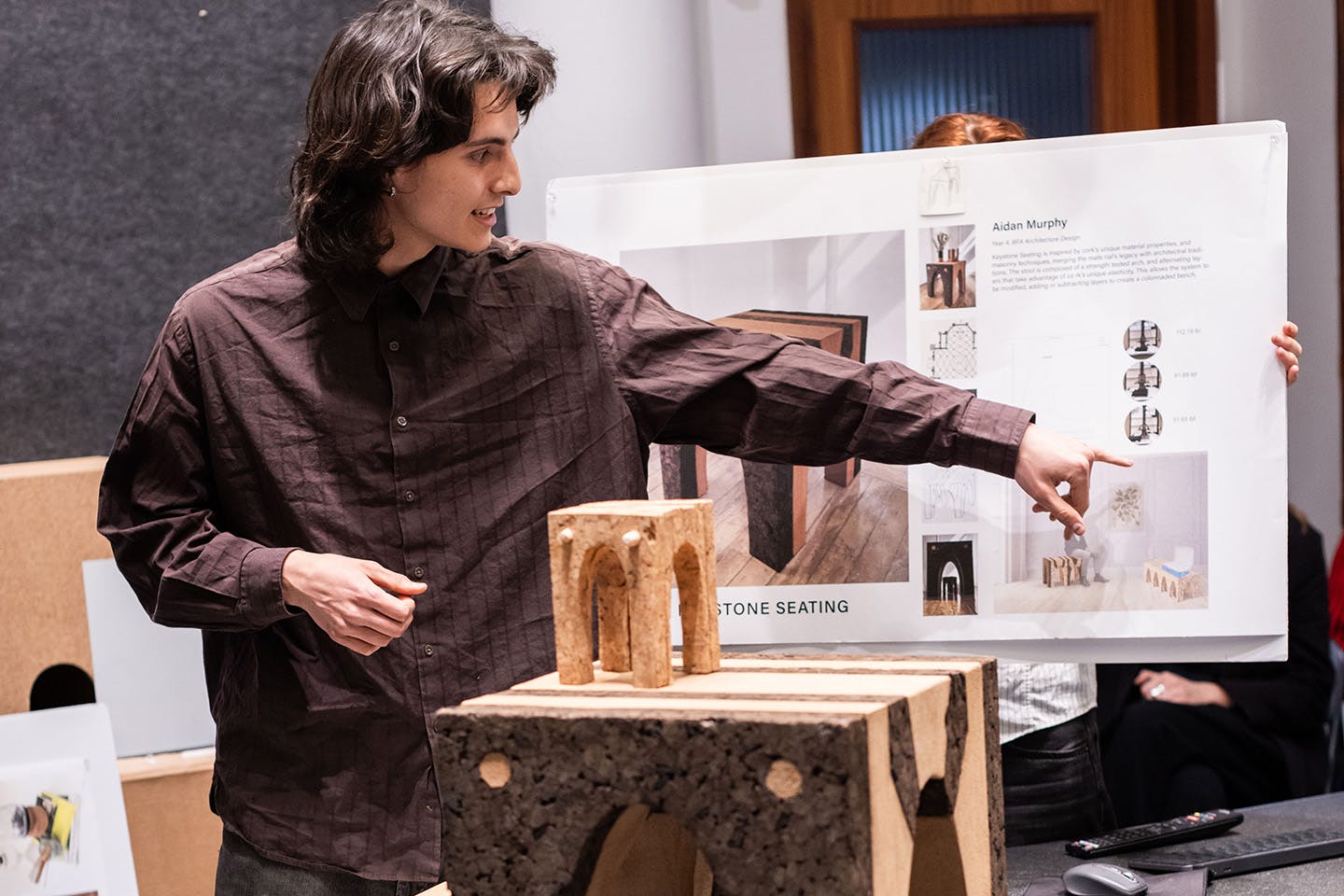 Aidan Murphy presents the components of his expandable cork bench to the crit panelist judges.