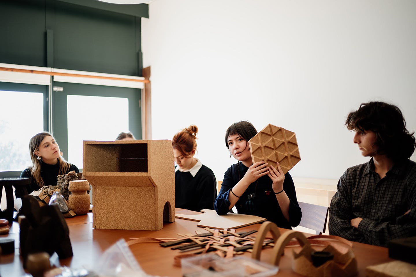 Students seated in a classroom setting, discussing their cork-based design projects during a session of Daniel Michalik’s course in Portugal.