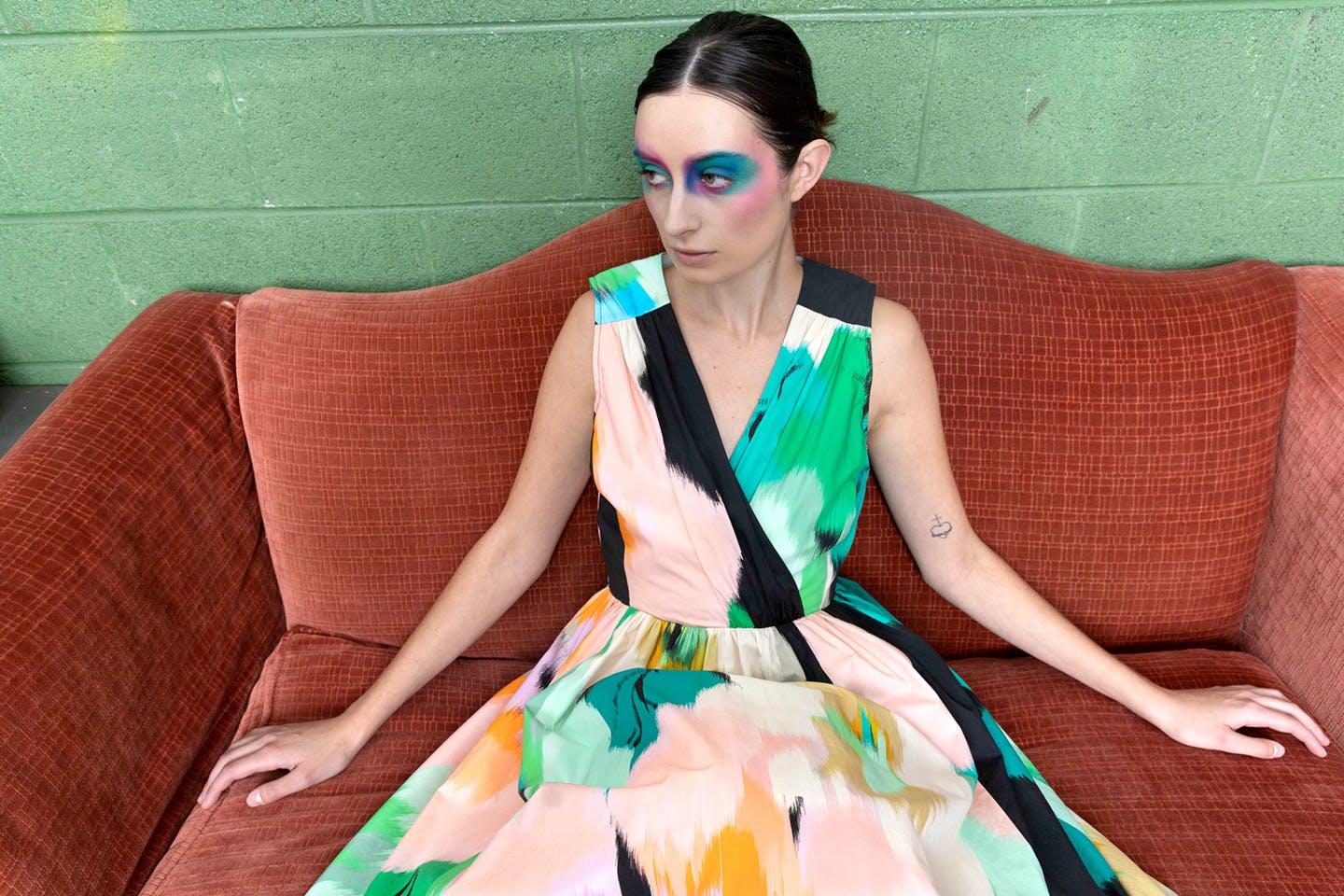 A model posing on a couch wearing Reese’s Bubble-Hem Midi-Dress.