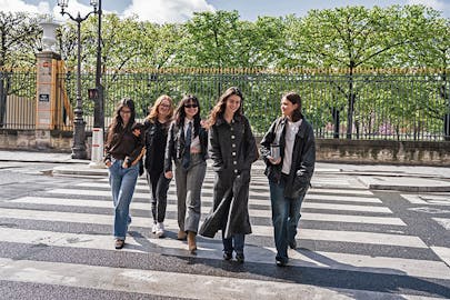 Students walk outside together in a group in Paris.