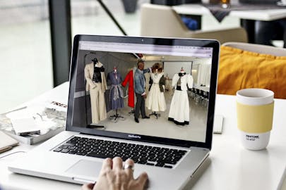 A fashion video plays on a laptop computer.