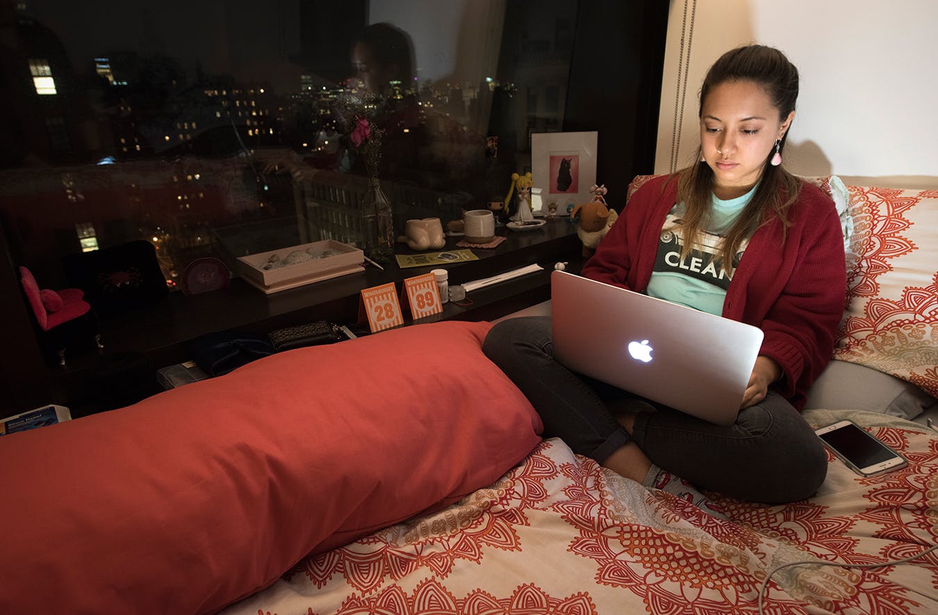 A student studies in her dorm room at night.