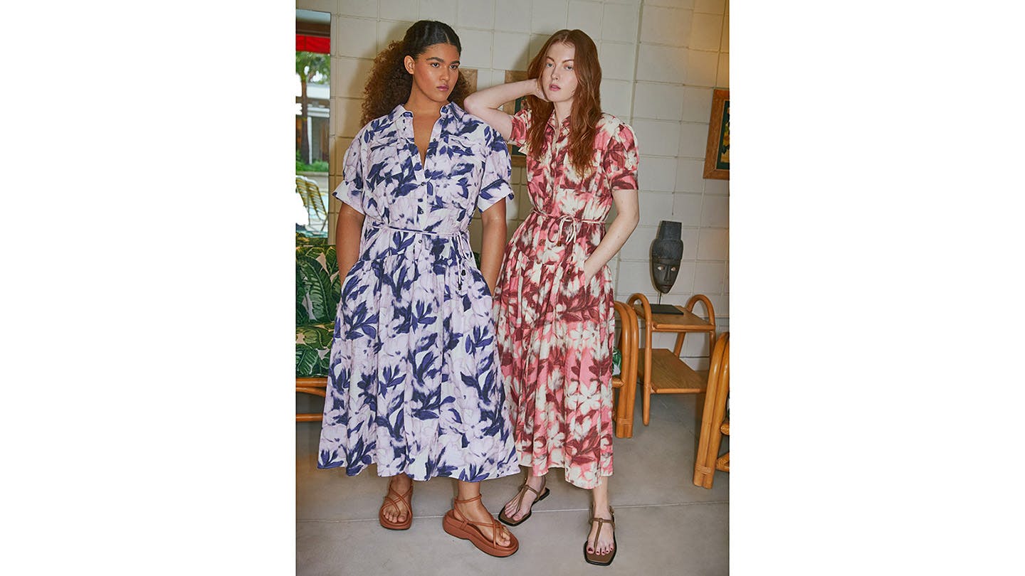 Two people wearing dresses in a handpainted pattern called Bellflower.