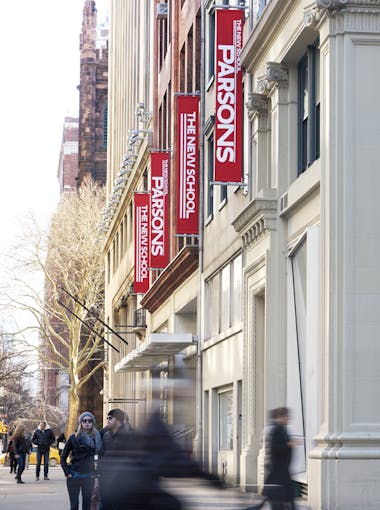 The Parsons Building on 5th Avenue, showing Parsons flags, and people walking on the sidewalk