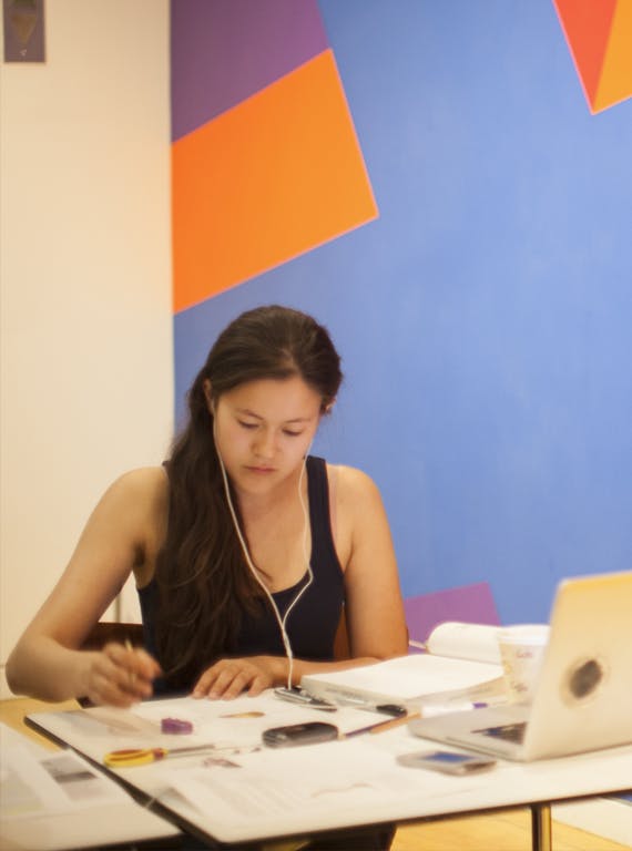A student wearing headphones works at a table