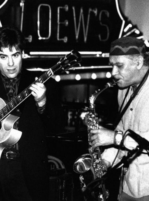 A guitarist and a saxophonist play jazz music together