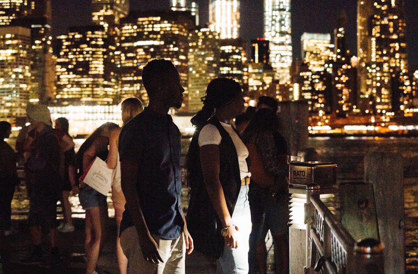 Students look out at the East River at night.