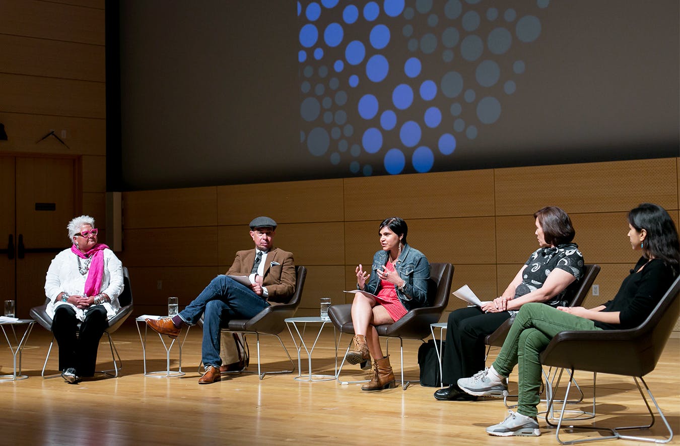 Several people on stage taking part in a panel discussion about Earth Day.