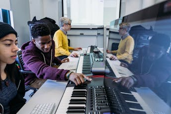 Several students are seated at a station in a Jazz technology course.